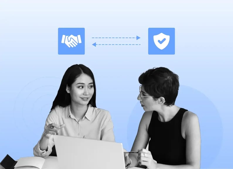 Two businesspeople sit next to each other at a desk, engaging in a discussion, symbolizing strong B2B relationships, collaboration and trust.