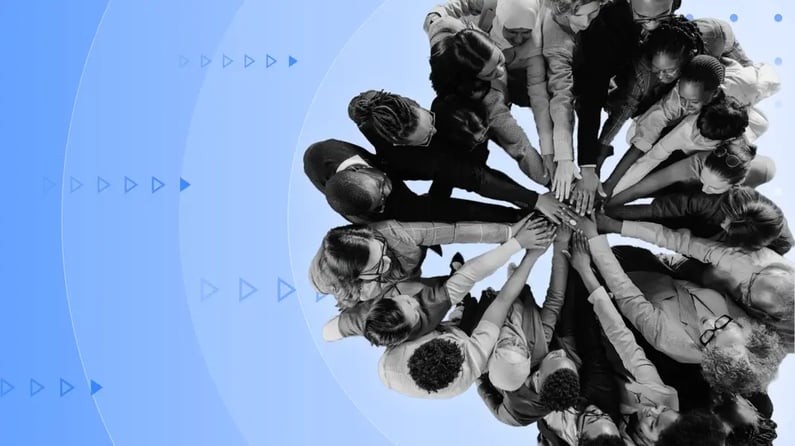 Overhead view of a team joining hands, symbolizing how trusted organizations foster unity and collaboration.