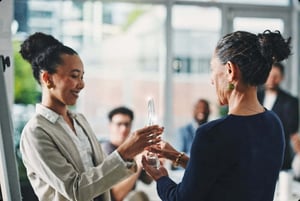 Business colleagues exchanging an award, representing recognition, achievement, and professional excellence.