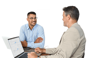 Business professionals reviewing performance data on a laptop during a strategic planning discussion.