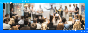 Audience applauding and taking photos as winners receive recognition on stage at an awards ceremony.