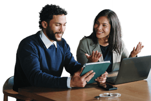 Business professionals reviewing data on a tablet and laptop during a collaborative planning discussion.