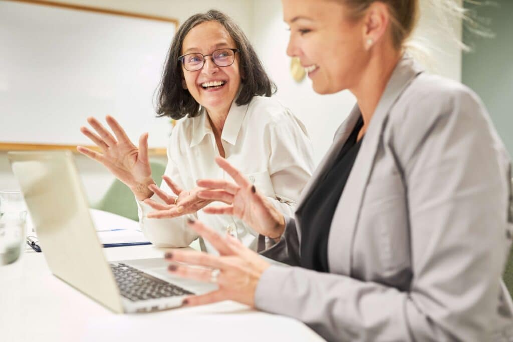 Two female co-workers in discussion  in bright office