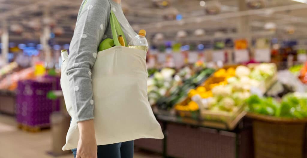 Female shopper in grocery store with eco-friendly products
